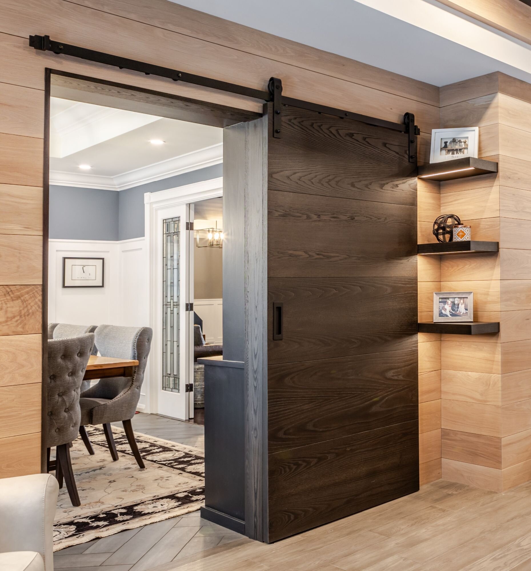 Custom wooden barn door designed by Homestead Woodworks, providing a rustic and stylish touch to the home's interior